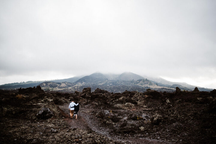 the couple walking in the black lava kintamani