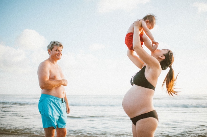 beach maternity photography of mommy holding up her son up to the sky