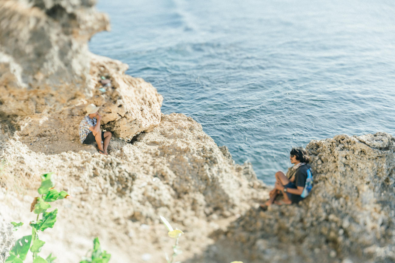 Two people waiting the sunset in the cliff side