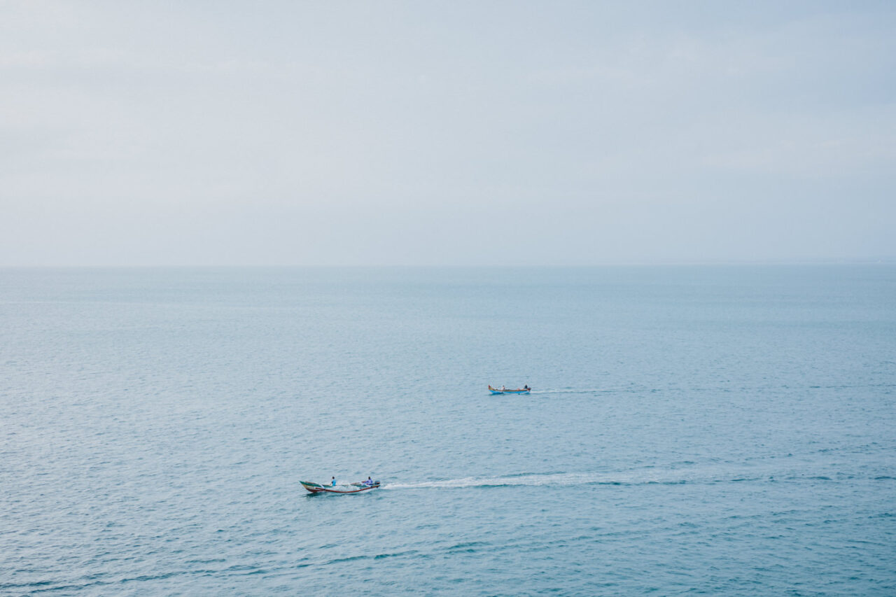Two boat are passing by on the ocean far