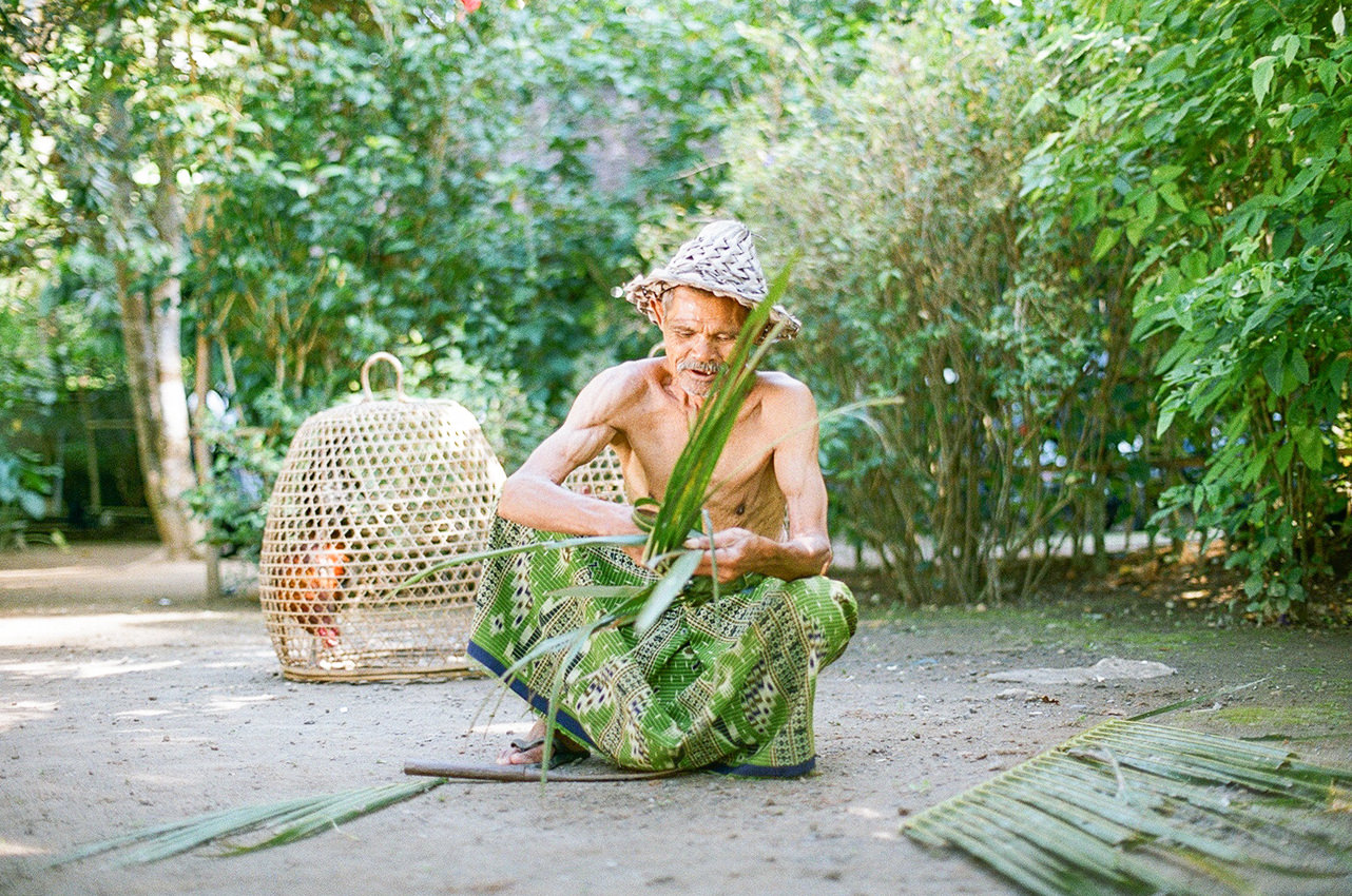 an old man making balinese traditional craft