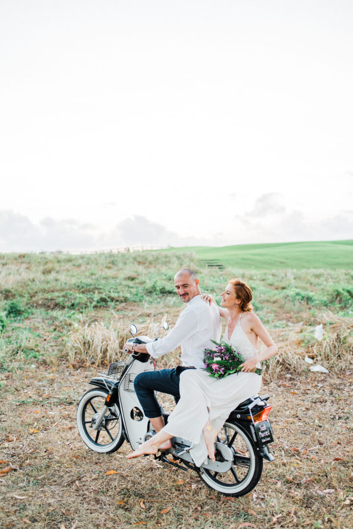 Lucyna and Kuba riding motorbike during their Bali elopement in New Kuta Golf