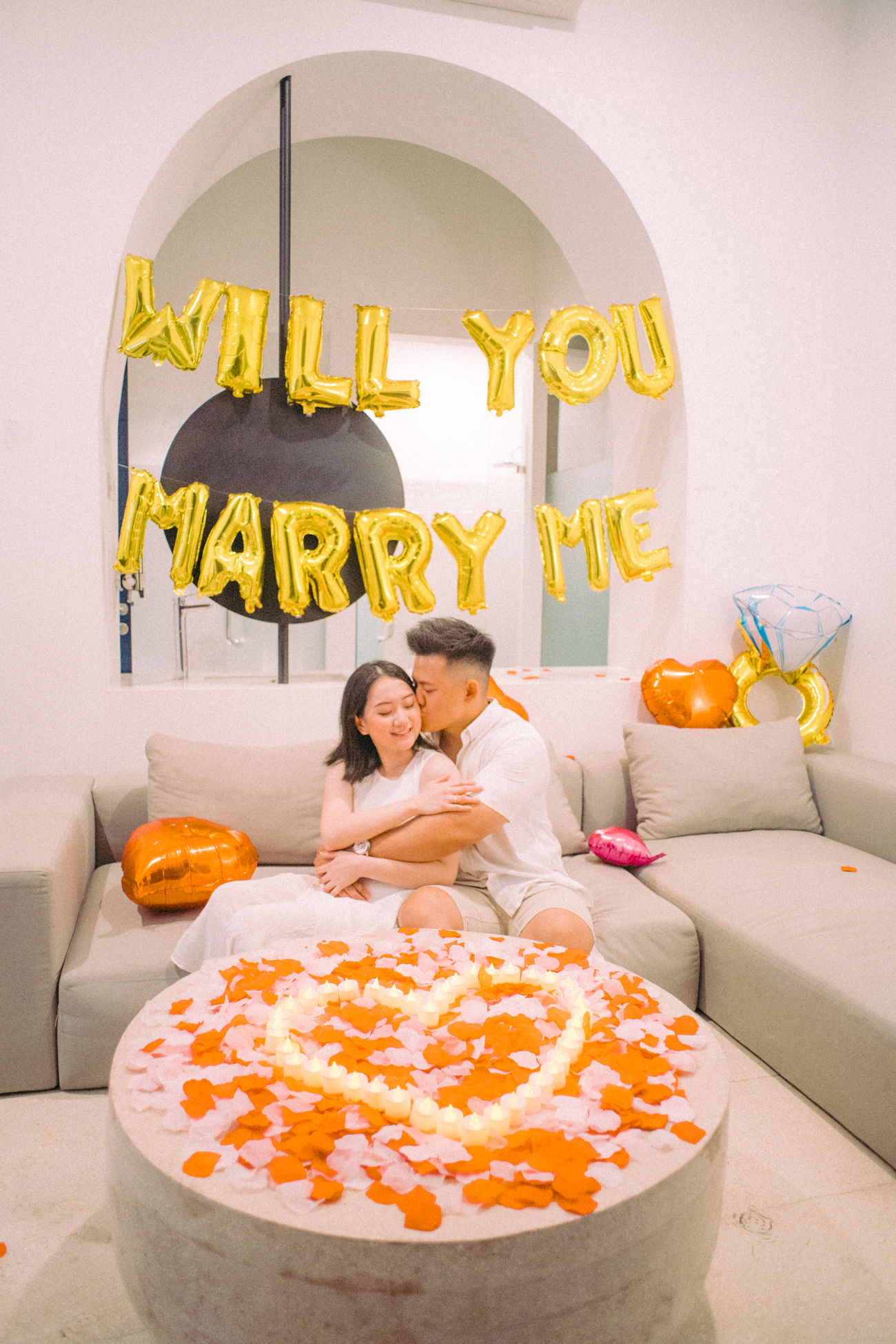 The man kiss the women in front of the sofa on pre-wedding proposal photo session