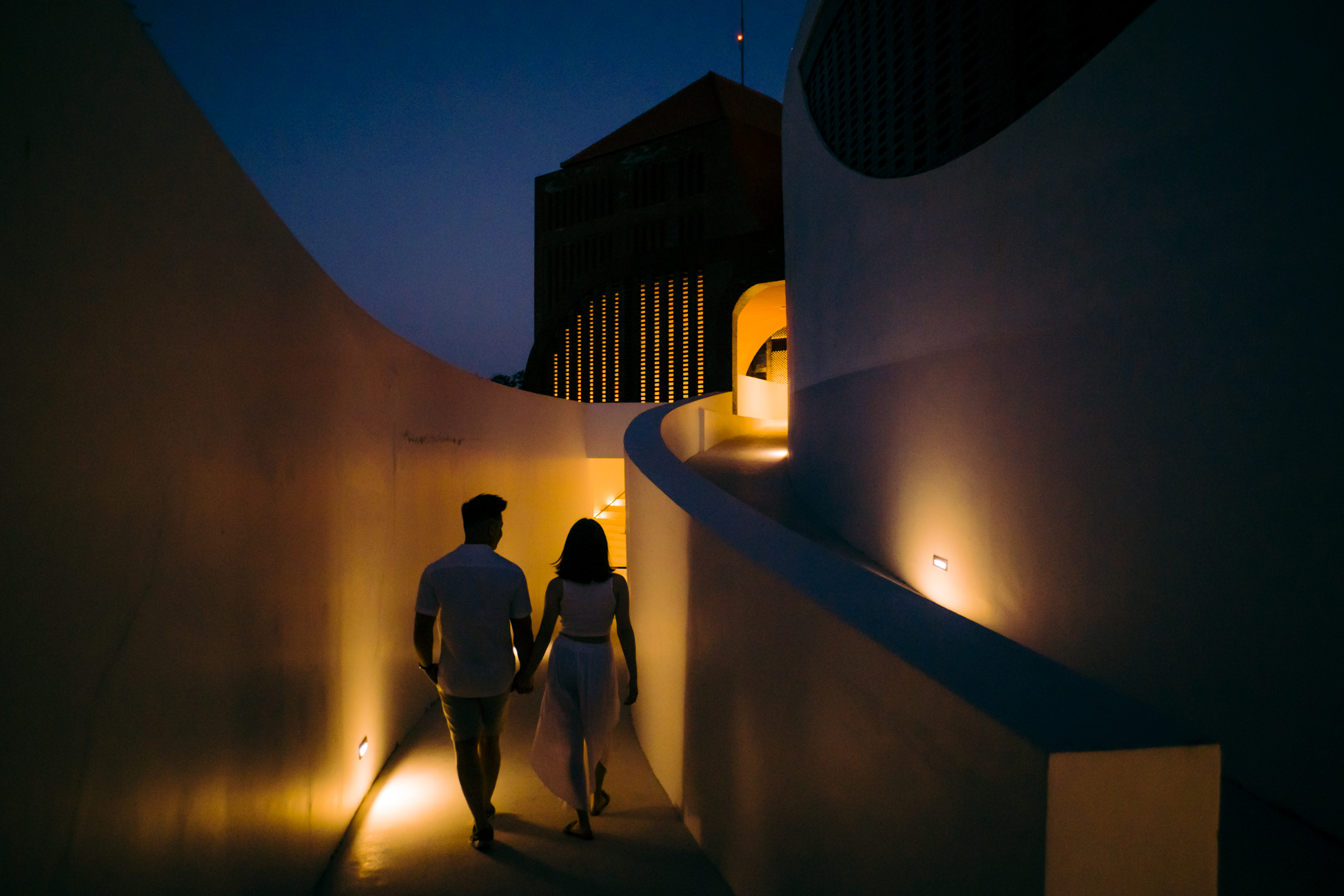 The couple walk through the entrance pathway on pre-wedding proposal photo session